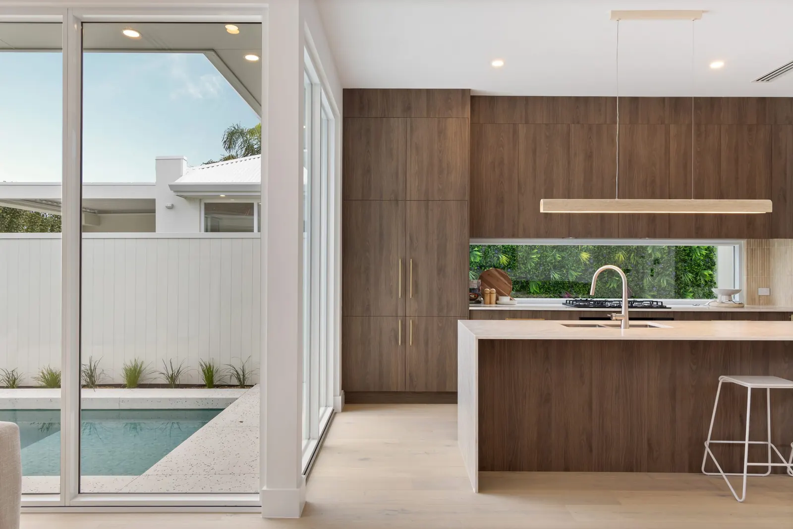 Timber kitchen opening onto a pool courtyard