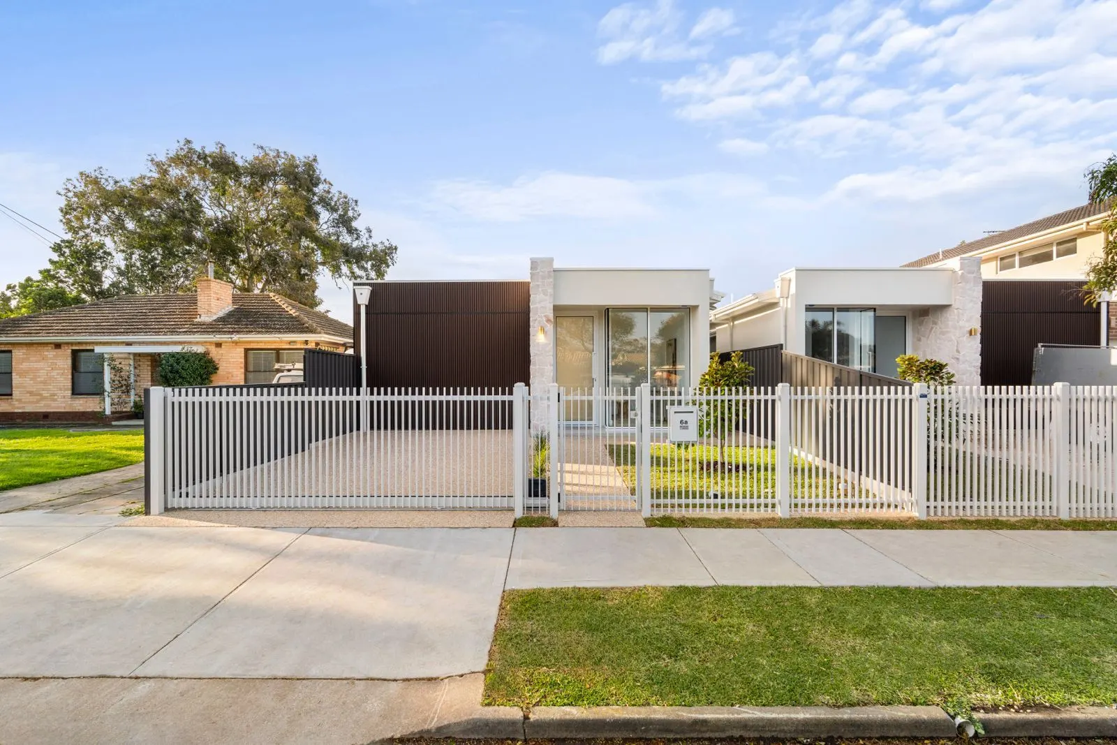 Pair of new homes behind white picket fencing