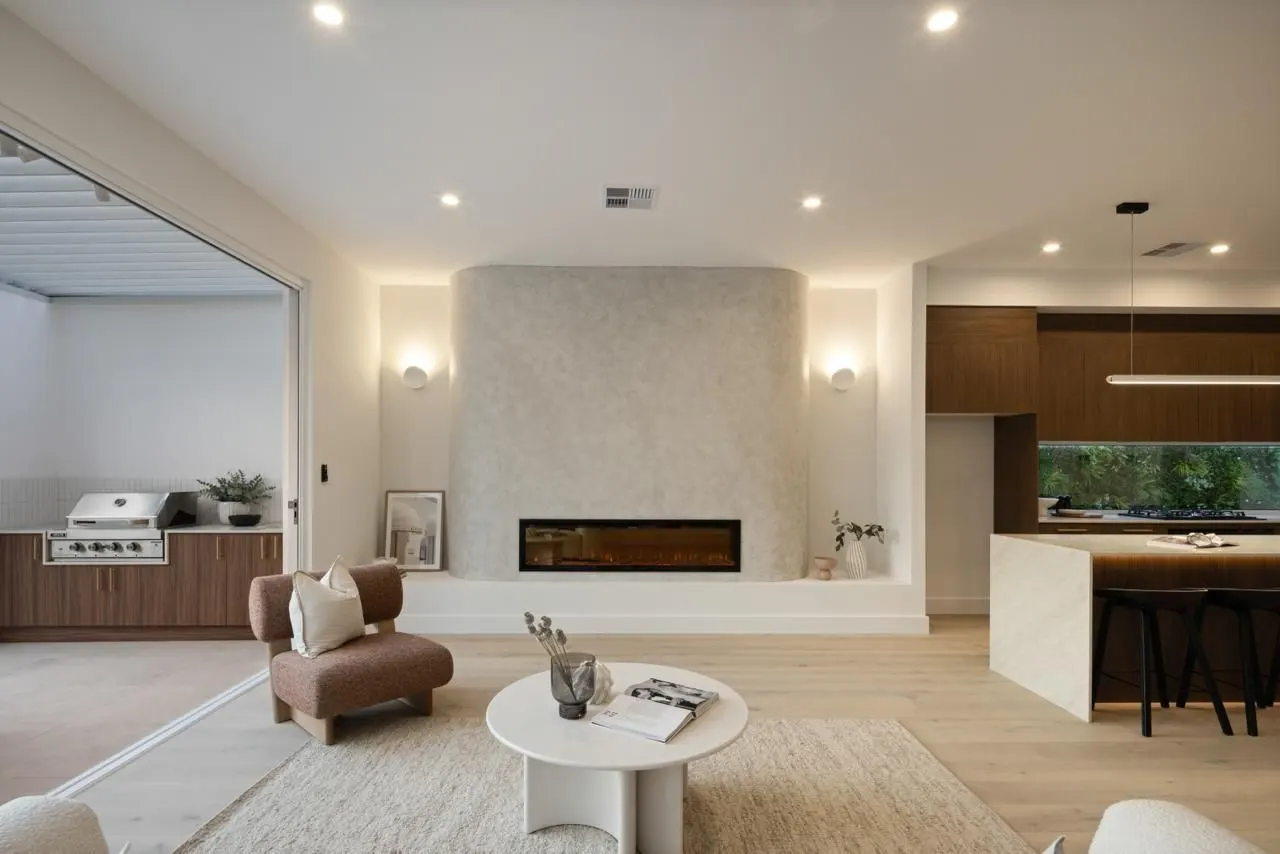 Living room with curved rendered fireplace