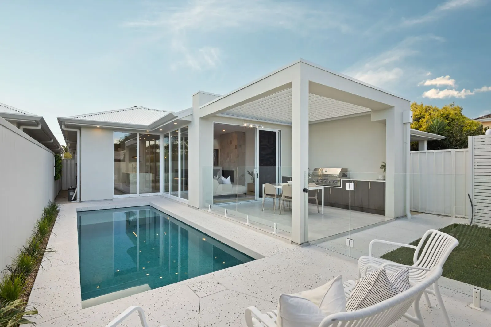 Backyard pool beside a louvred alfresco
