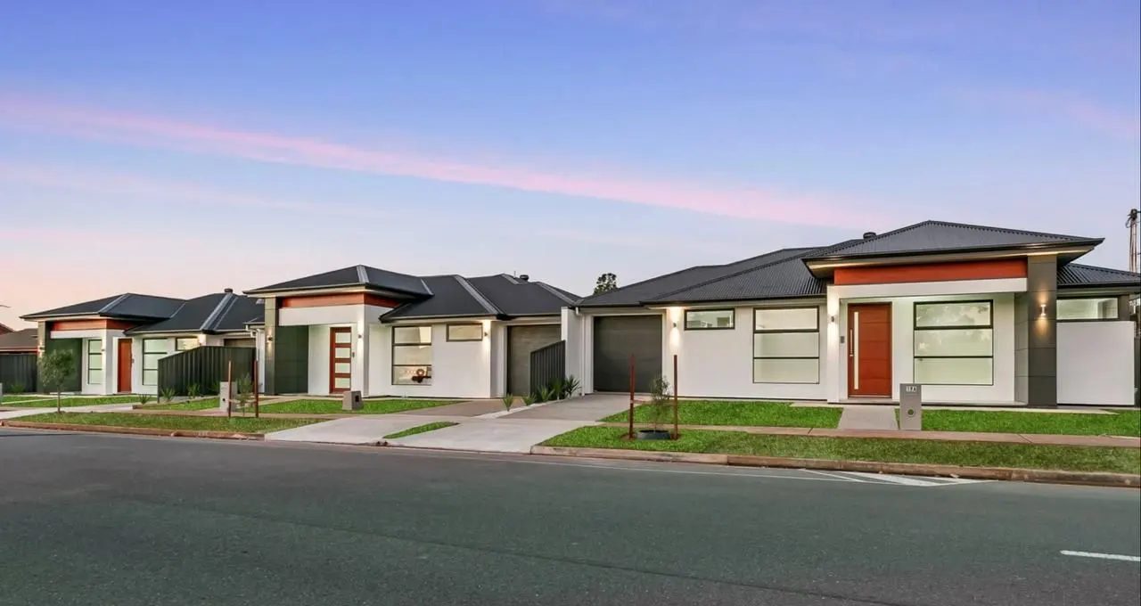 Row of new single-storey homes at dusk