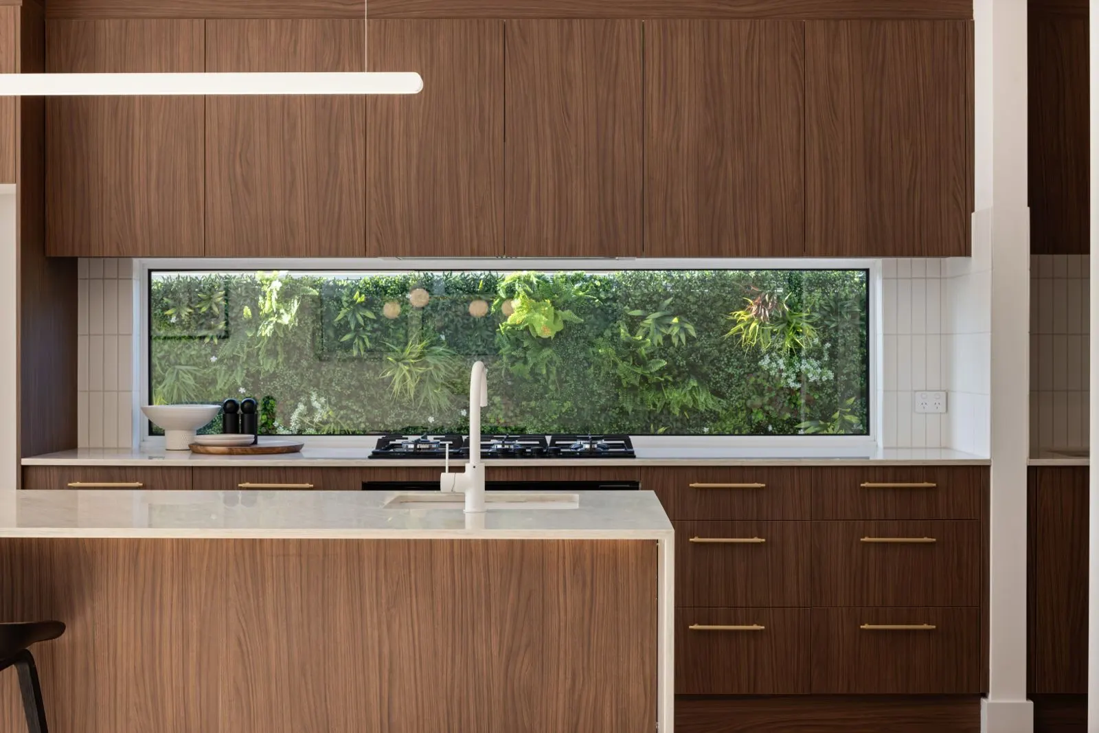 Walnut kitchen with garden-view window splashback
